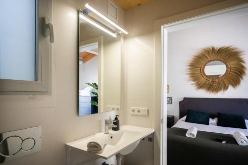 Un baño con lavabo, espejo y cama. en Total Valencia Ayuntamiento, en Valencia