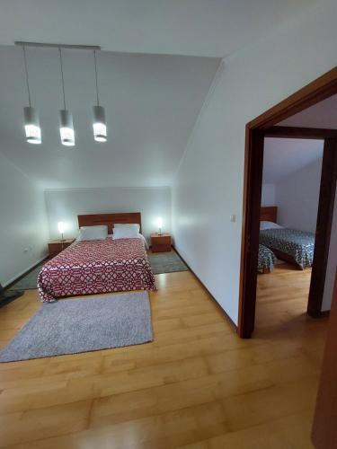 a large bedroom with a bed and a mirror at Lameiros Cottage in São Vicente