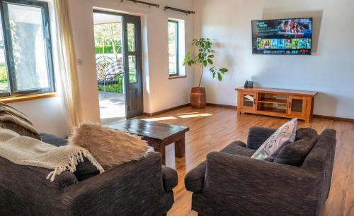 Sala de estar con 2 sofás y mesa en The Cabin, en Nakuru