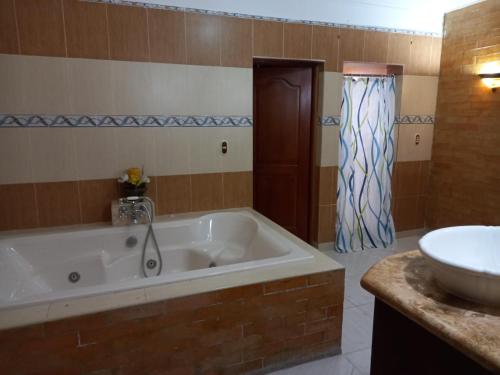a bathroom with a large tub and a sink at Penthouse con jacuzzi La cueva de los 3 ojos in Santo Domingo