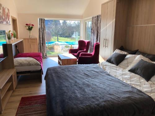a bedroom with a bed and a chair and a window at U Fousáče in Hrabětice