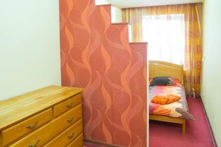 1 dormitorio con 1 cama y vestidor junto a la pared en 2-х комнатная на Подоле, en Kiev