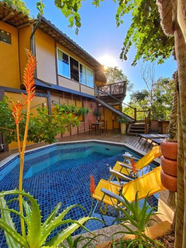 a house with a swimming pool in front of a house at Pousada Enseada das Garças in São Pedro da Aldeia
