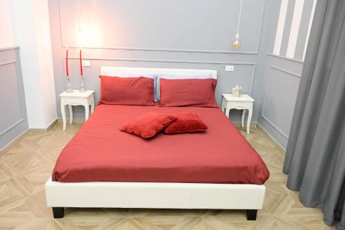 1 cama con sábanas rojas y 2 almohadas rojas en B&B Orchidea Celeste en Manfredonia