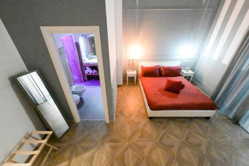 a small bedroom with a red bed and a mirror at B&B Orchidea Celeste in Manfredonia