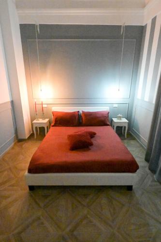 a bedroom with a large red bed with two tables at B&B Orchidea Celeste in Manfredonia