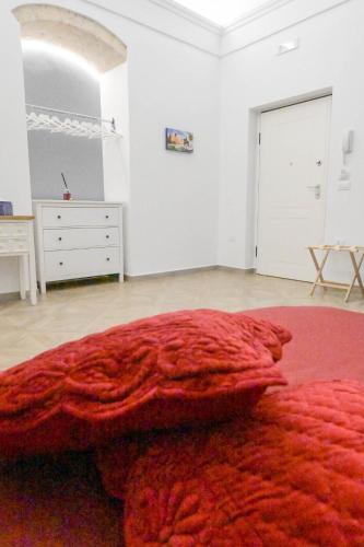 a bedroom with a large red blanket on the floor at B&B Orchidea Celeste in Manfredonia
