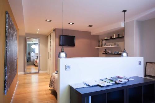 ein Wohnzimmer mit einem Tisch und einem TV in der Unterkunft Piso moderno, céntrico y con garaje gratis in Bilbao