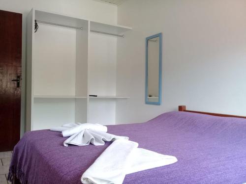 Un dormitorio con una cama morada con toallas. en Pousada Santo Sol, en Florianópolis