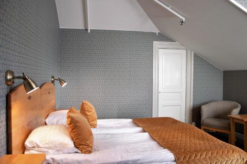 a bedroom with a bed and a chair in it at Mössebergs Kurort in Falköping