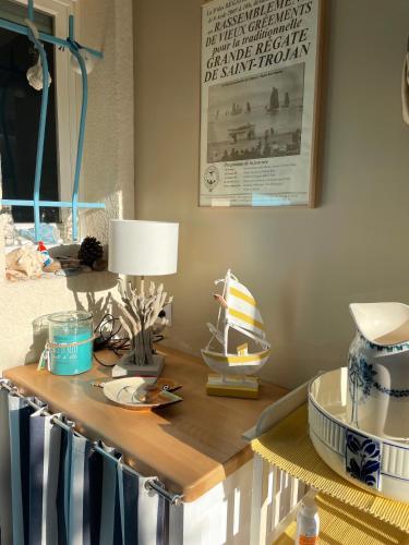 une table avec une lampe et un bateau dessus dans l'établissement LES MIMOSAS, à Saint-Trojan-les-Bains