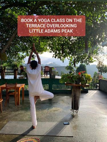 a man performing a yoga class on the terrace overlookinglittleannispeak at Ella Nimal Nest Inn in Ella