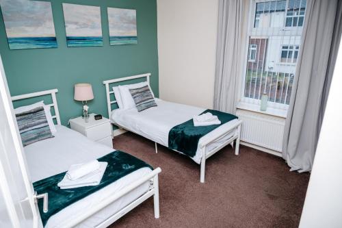 two beds in a small room with a window at Woodhouse Lodge in Woodhouse