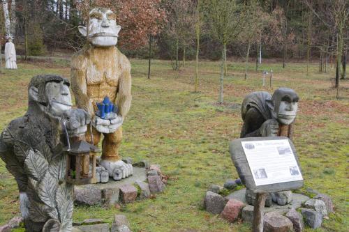 two statues of people wearing masks and a sign at Bestwaner Hotel in Bestensee