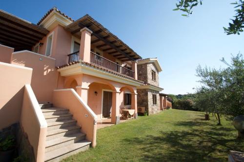 a large house with stairs and a grass yard at Le Dimore di Nettuno in Olbia