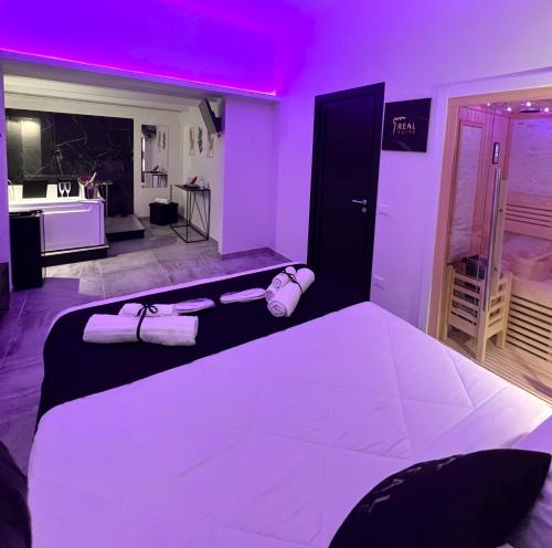 a bedroom with a large bed with purple lighting at Real suite spa in Palermo