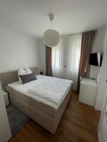 a bedroom with a white bed and a chandelier at Villa DEA - Luxus Ferienhaus in Kroatien mit beheizten Pool Vrsi-Mulo bei Zadar in Vrsi