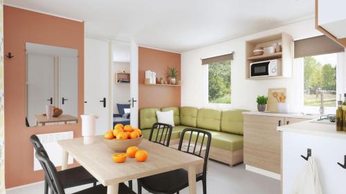 een keuken en een woonkamer met een tafel met sinaasappels erop bij Camping Domaine Du Golfe De Saint Tropez in Grimaud