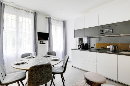 une salle à manger avec une table et des chaises et une cuisine dans l'établissement Charming apart -1BR-5P - République, à Paris