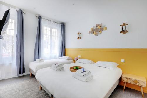 une chambre avec deux lits avec des serviettes dessus dans l'établissement Charming apart -1BR-5P - République, à Paris