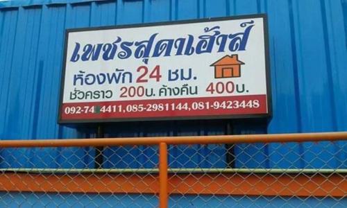una señal en el costado de una pared azul en เพชรสุดาเฮ้าส์ en Phetchaburi