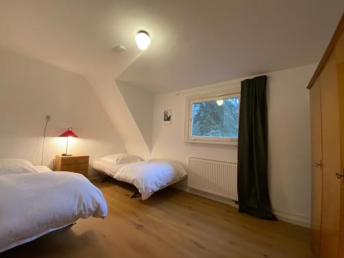 1 dormitorio con 2 camas y ventana en Ferienhaus Waldglück, en Calw