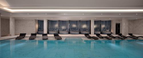 a swimming pool in a hotel with black chairs at Fairmont Windsor Park in Windsor