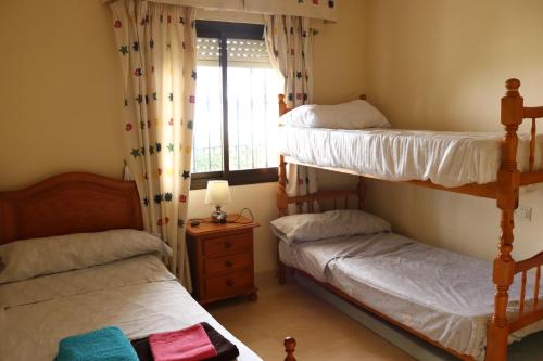 dwa łóżka piętrowe w pokoju z oknem w obiekcie Apartamento Bellasol w mieście Mijas
