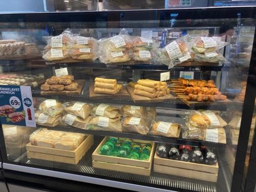 a display case in a store filled with lots of food at Motel Trafikcenter Sæby in Sæby