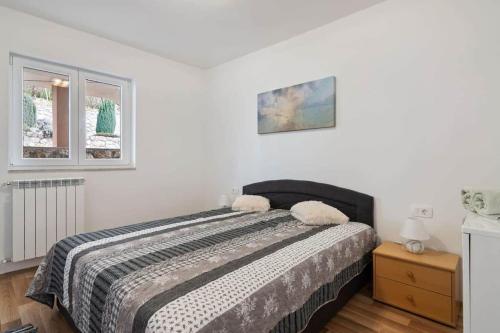 a bedroom with a bed and two windows at Villa Olivia in Veprinac