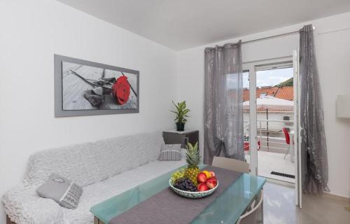 een woonkamer met een bank en een fruitschaal op een tafel bij Stuck in the Moment Apartment in Dubrovnik