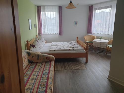 a room with a bed and a couch and windows at Gästehaus zum Georgenberg in Goslar