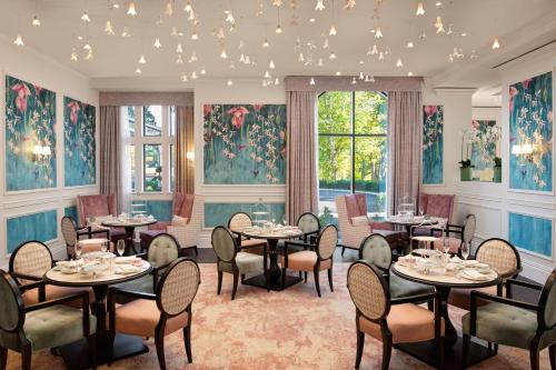 a dining room with tables and chairs and windows at Fairmont Windsor Park in Windsor