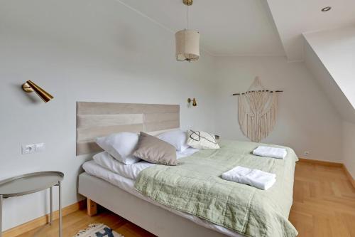 a bedroom with a bed with a green blanket at Grand Apartments - Boho Sopot Apartament dwupoziomowy in Sopot