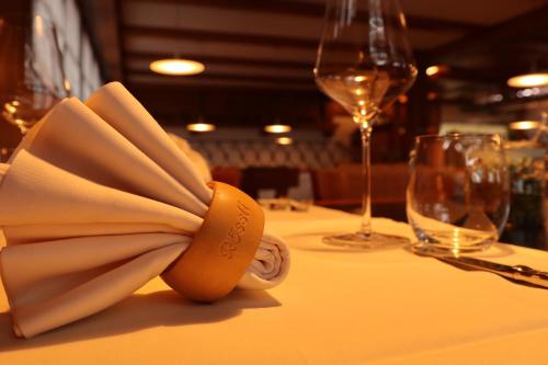 a table with a napkin and wine glasses on it at Hotel Restaurant Rössli in Alt Sankt Johann