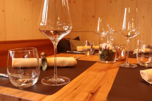 a wooden table with wine glasses on top of it at Hotel Restaurant Rössli in Alt Sankt Johann