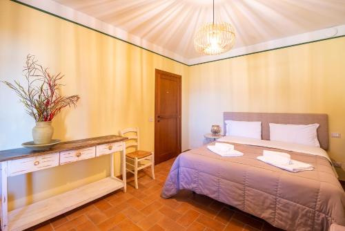 a bedroom with a bed and a table with a plant on it at Agriturismo Le Vigne in Foligno