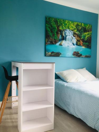 - une chambre avec un lit et une peinture murale représentant une cascade dans l'établissement Studio 2 bien agencé et tout équipé, à Lorient