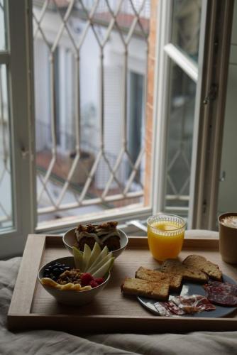 a table with a tray of breakfast foods and an orange juice at Plácido y Grata in Seville