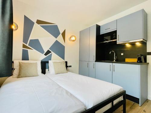 a large bed in a room with a kitchen at City Apartments Grendelplein in Valkenburg