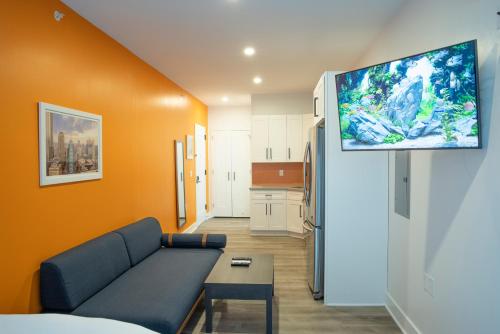 ジャージー・シティーにあるPeachtree Suites - Jersey Cityのソファと薄型テレビのあるリビングルーム