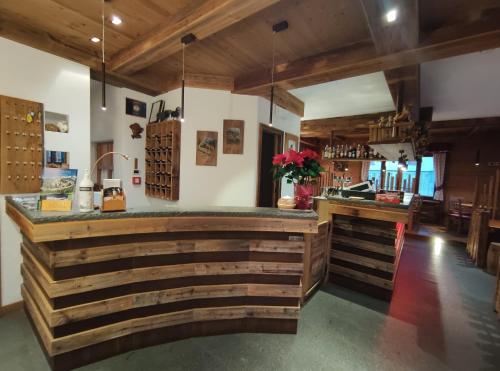 a bar in a restaurant with wooden walls at Hotel Milano in Piazzatorre