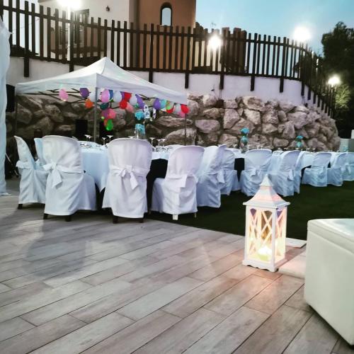 a set up for a wedding with white tables and chairs at Imperial Park in Raffadali