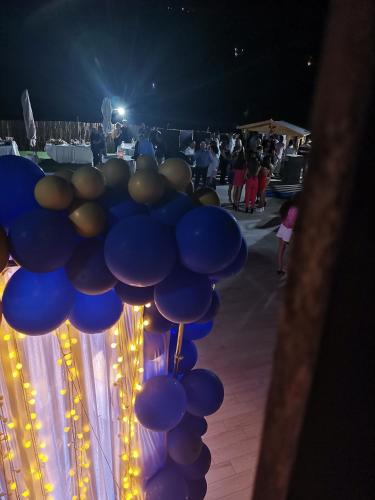 a bunch of blue balloons are lit up at night at Imperial Park in Raffadali