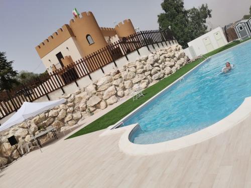 a person swimming in a swimming pool next to a house at Imperial Park in Raffadali