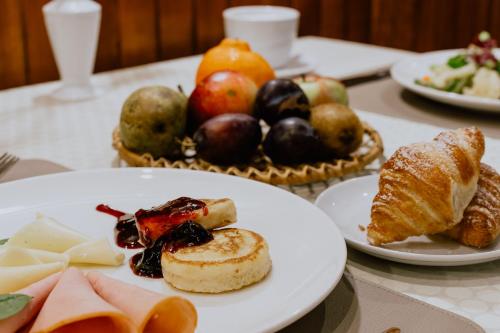 a table topped with plates of food and fruit at Green Gile Villa in Druskininkai Center in Druskininkai