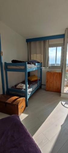 une chambre avec deux lits superposés et une fenêtre dans l'établissement Agréable studio bord de mer, à Saint-Cyprien