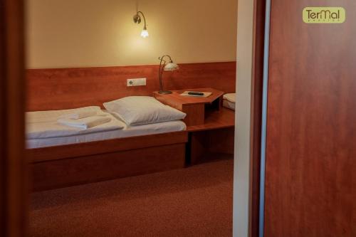 a bedroom with a bed and a desk with a lamp at Penzion Termal in Bojnice