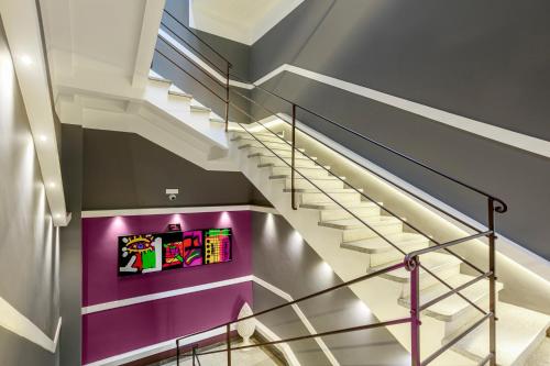 a set of stairs with a purple wall at Manzoni 46 - Ospitalità siciliana in Milazzo