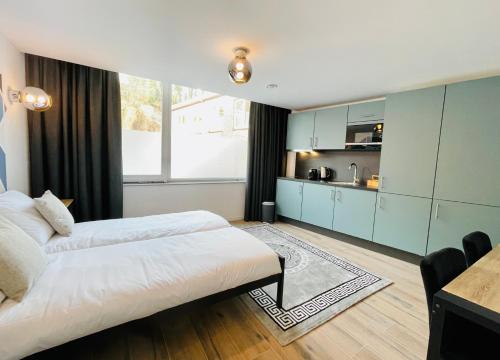 a large bedroom with two beds and a kitchen at City Apartments Grendelplein in Valkenburg